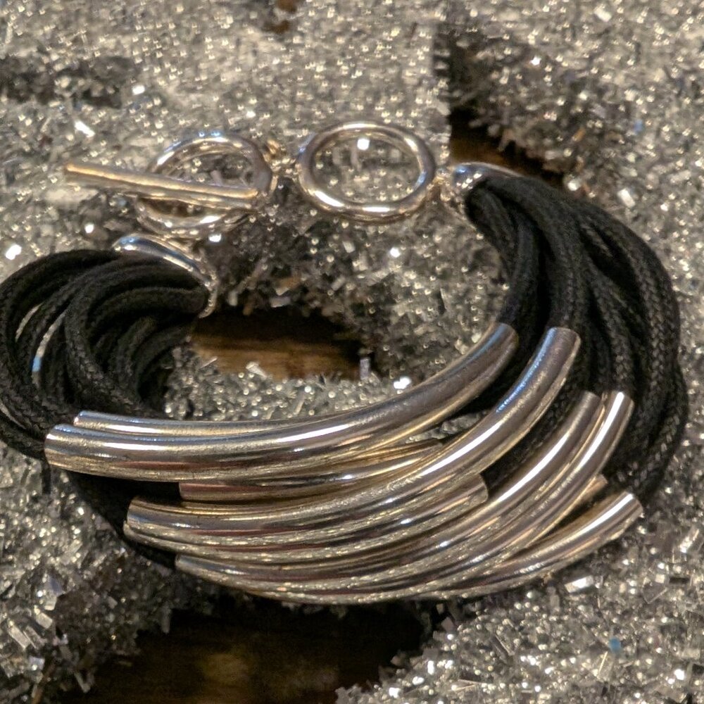 12 Strand waxed black cotton, 12 silver tubes, unique clasp